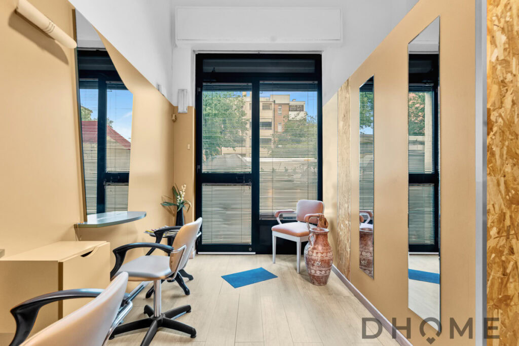 Salone di estetista con specchi e sedie eleganti, ambiente luminoso e accogliente.