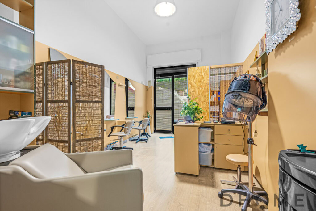 Interni salone di bellezza o salone di parrucchiere, arredi moderni e accoglienti, ambiente luminoso, sedie per clienti, strumenti per capelli, stile professionale.