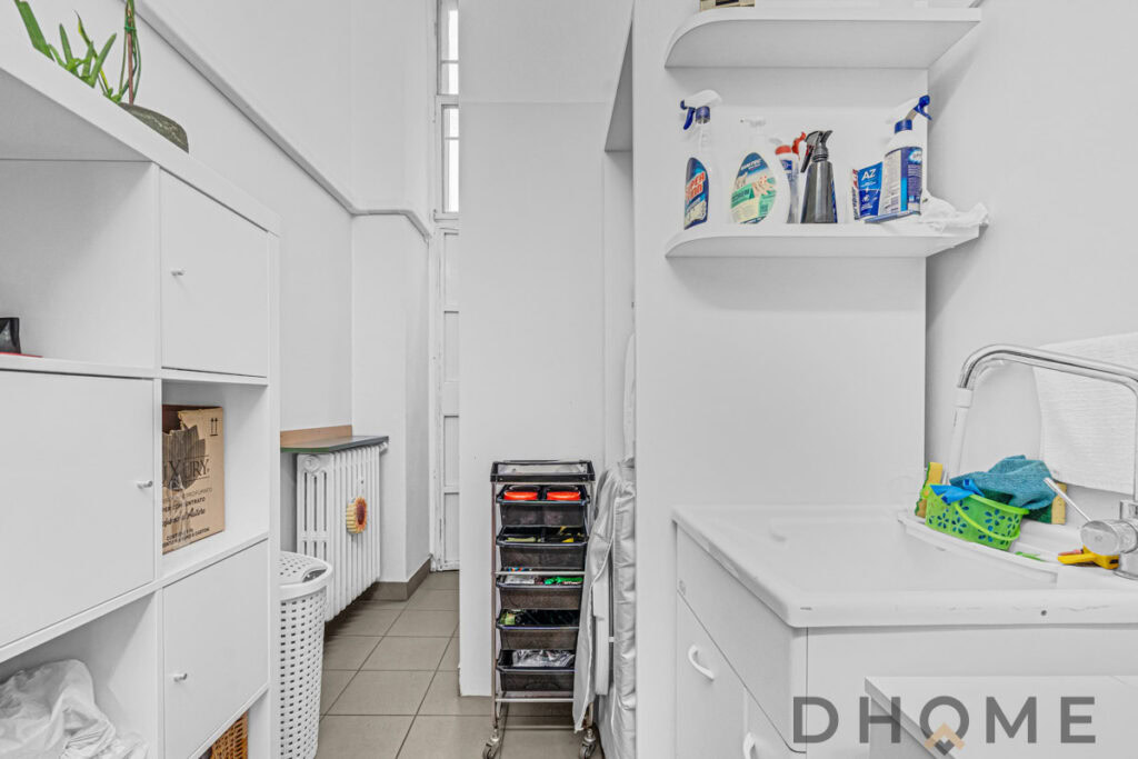 Cestino della spazzatura e scaffali con prodotti per la pulizia in lavanderia domestica.