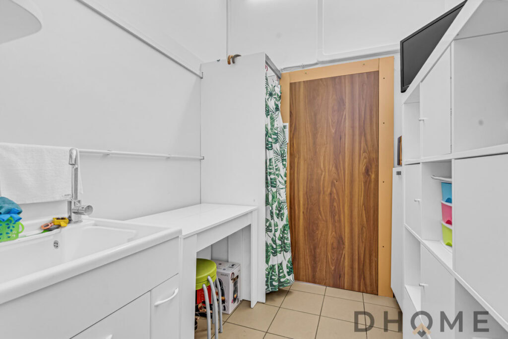 Lavatrice e lavello in lavanderia, arredo funzionale e spazio di stoccaggio efficiente.