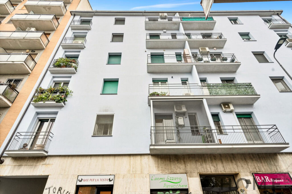 Balcone di appartamento residenziale con piante e aria condizionata, edificio moderno.