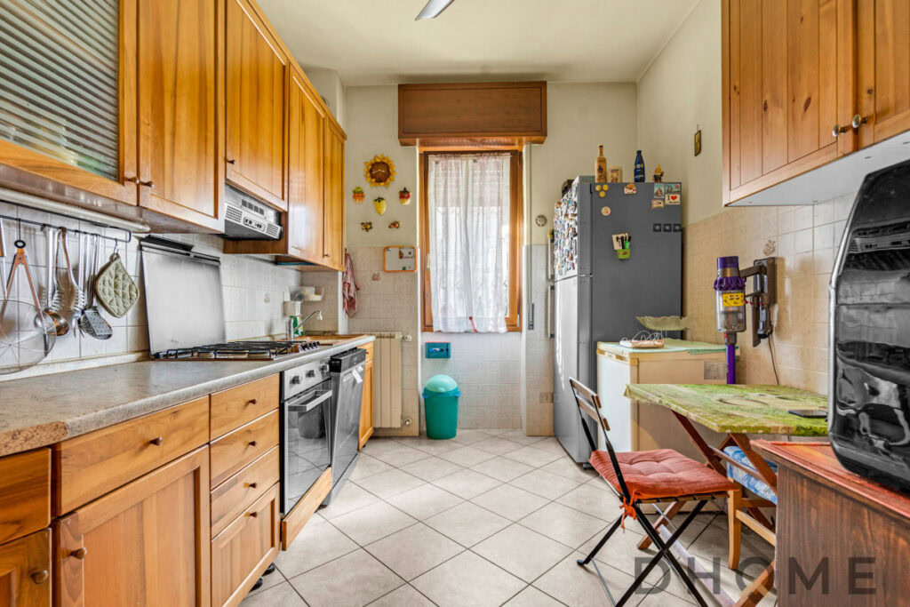 Cucina abitabile in stile rustico con mobili in legno e elettrodomestici moderni.