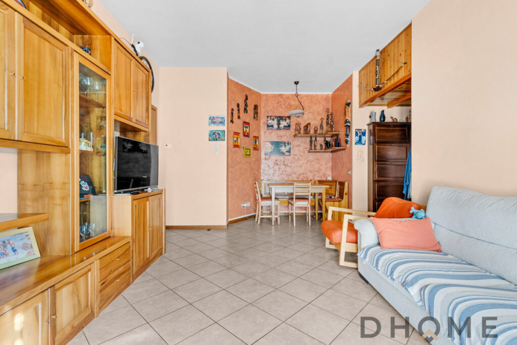 Divano e zona soggiorno con mobile in legno e decorazioni artistiche.