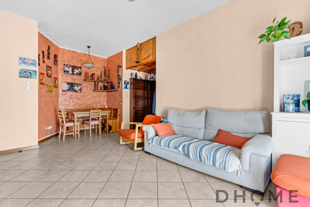 Accogliente soggiorno con divano e zona pranzo in stile warm, ideale per relax e convivialità.