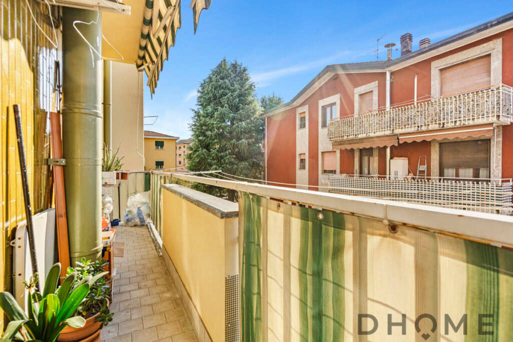 Balcone spazioso con vista su edifici residenziali e alberi, in zona tranquilla.