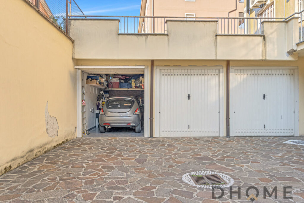 Capannone garage con spazio di parcheggio e area di deposito esterna.