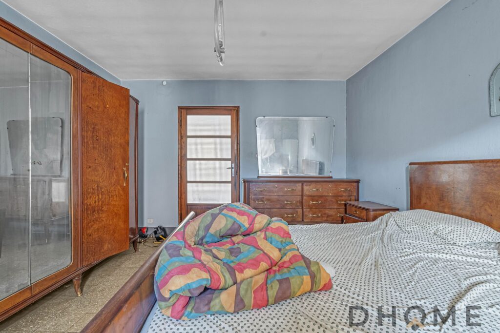 Casa indipendente in vendita a Primaluna, camera da letto arredata con mobili in legno e finestra lu.