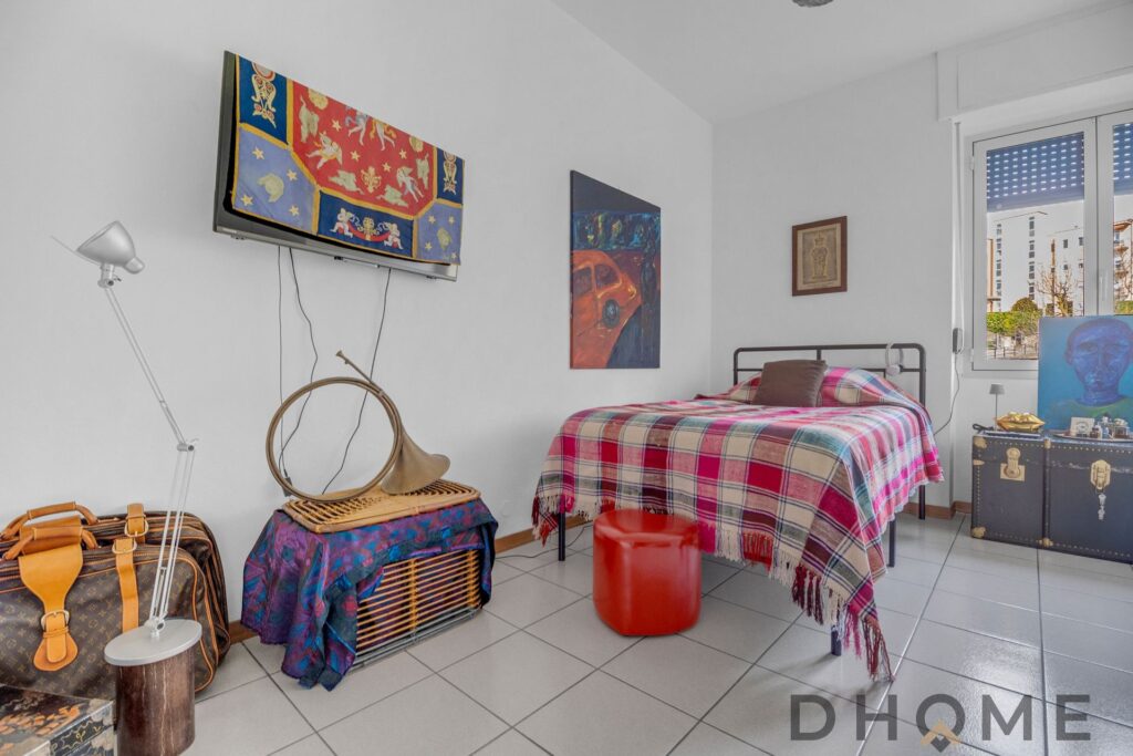 Appartamento luminoso con camera da letto, decorazioni colorate e arredi moderni a Como.