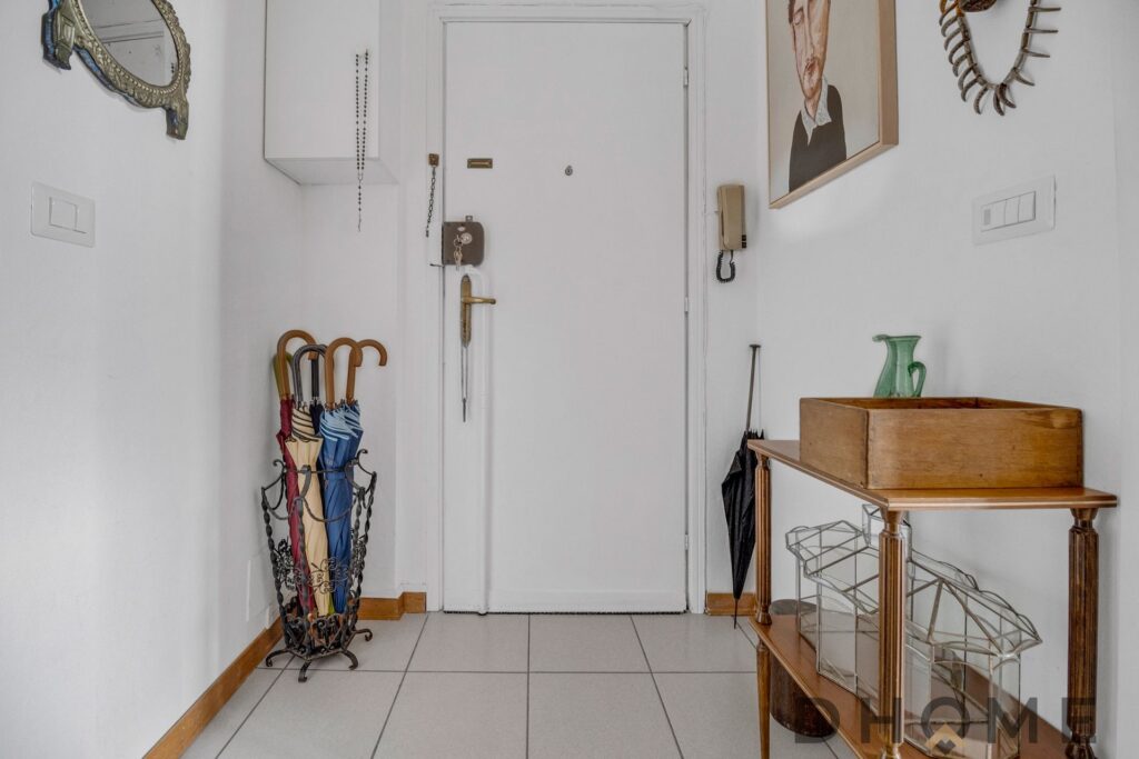 Ingresso luminoso con pareti bianche e decorazioni eleganti.
