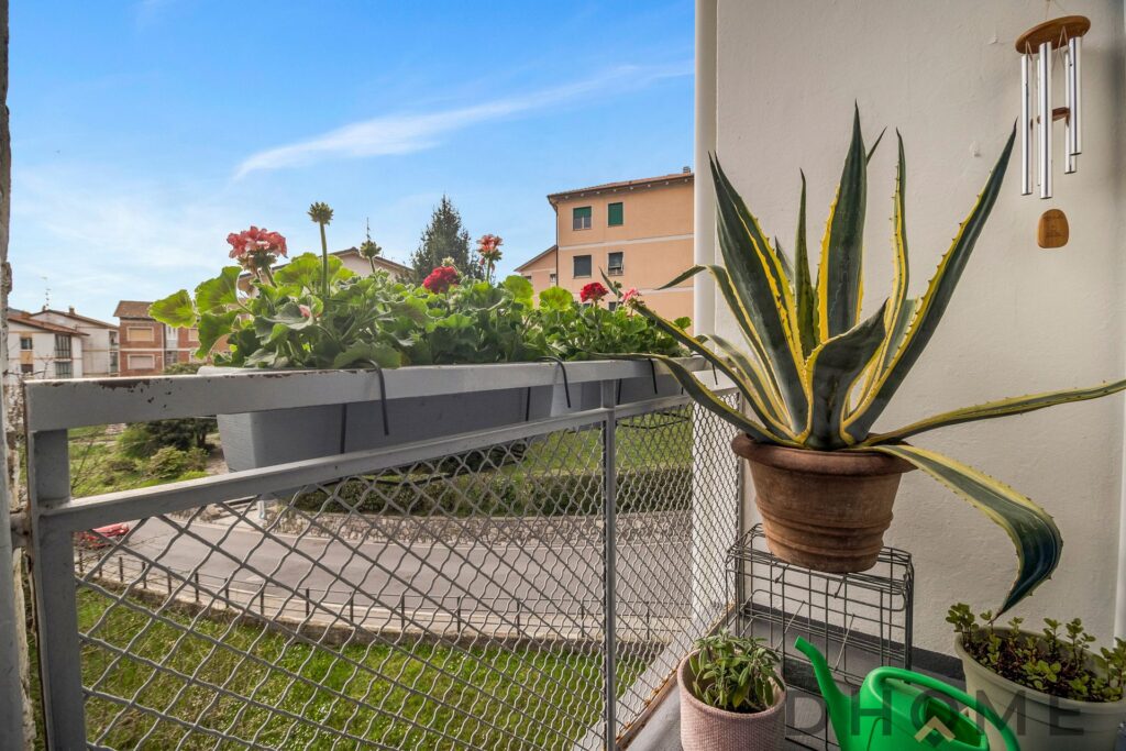 Balcone di un trilocale luminoso a Como con piante e vista sulla città.