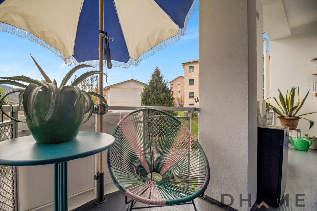 Balcone luminoso con vista su zona residenziale a Como, ideale per relax e momenti all'aperto.