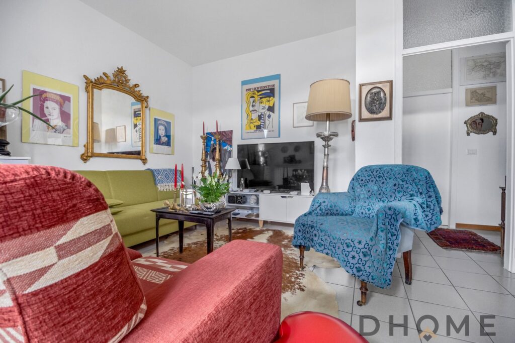 Soggiorno luminoso con arredi colorati e decorazioni artistiche, ideale per vivere in un ambiente ac.