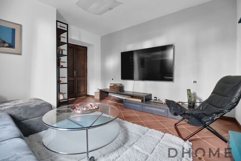 Casa con soggiorno spazioso, TV a parete e arredi eleganti a Margno.