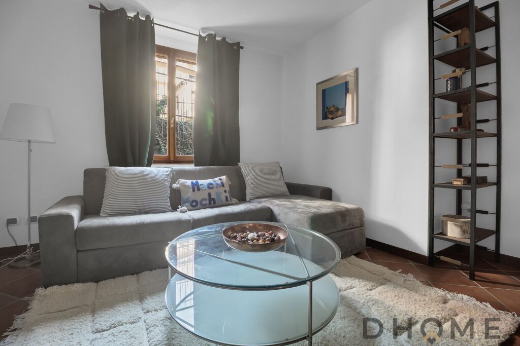 Soggiorno accogliente con divano e finestra luminosa.