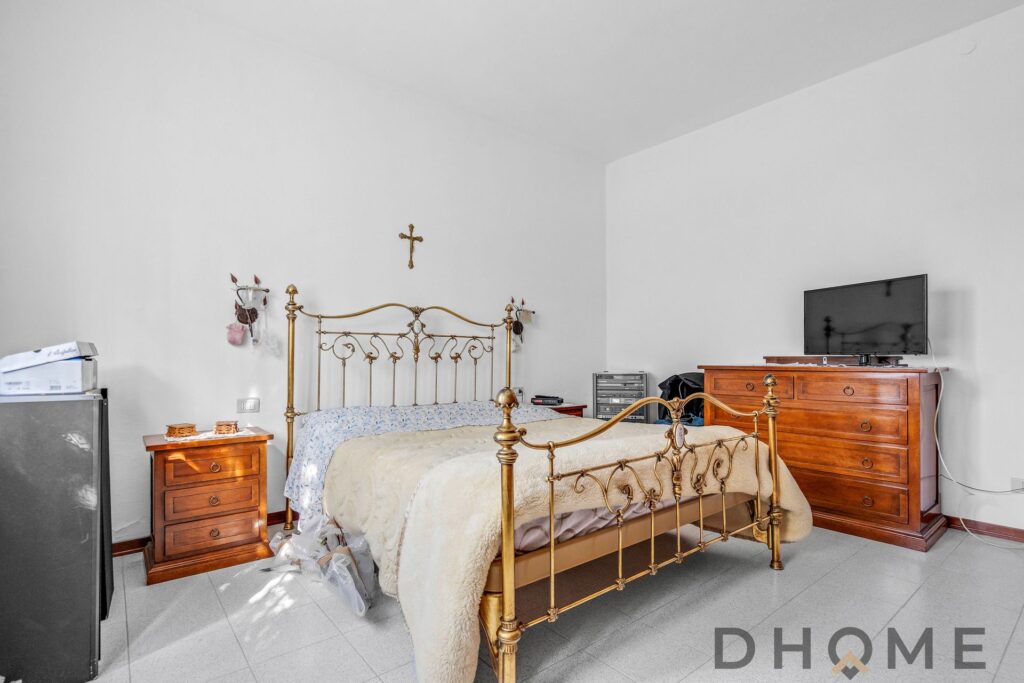 Camera da letto con letto in ferro battuto e arredi classici.