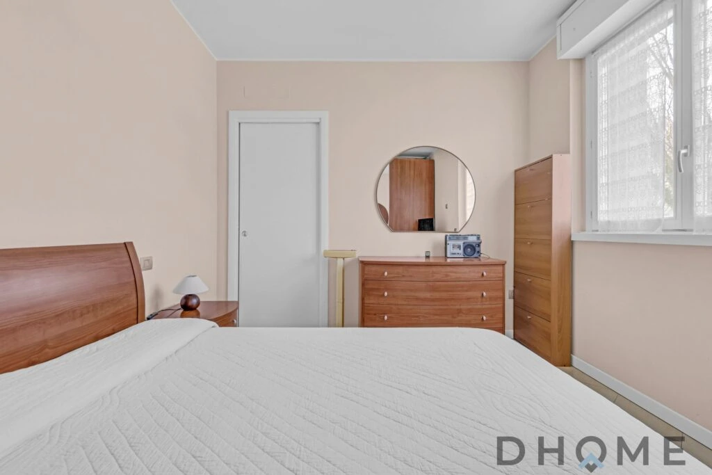 Appartamento in vendita con camera matrimoniale, armadio e finestra luminosa.