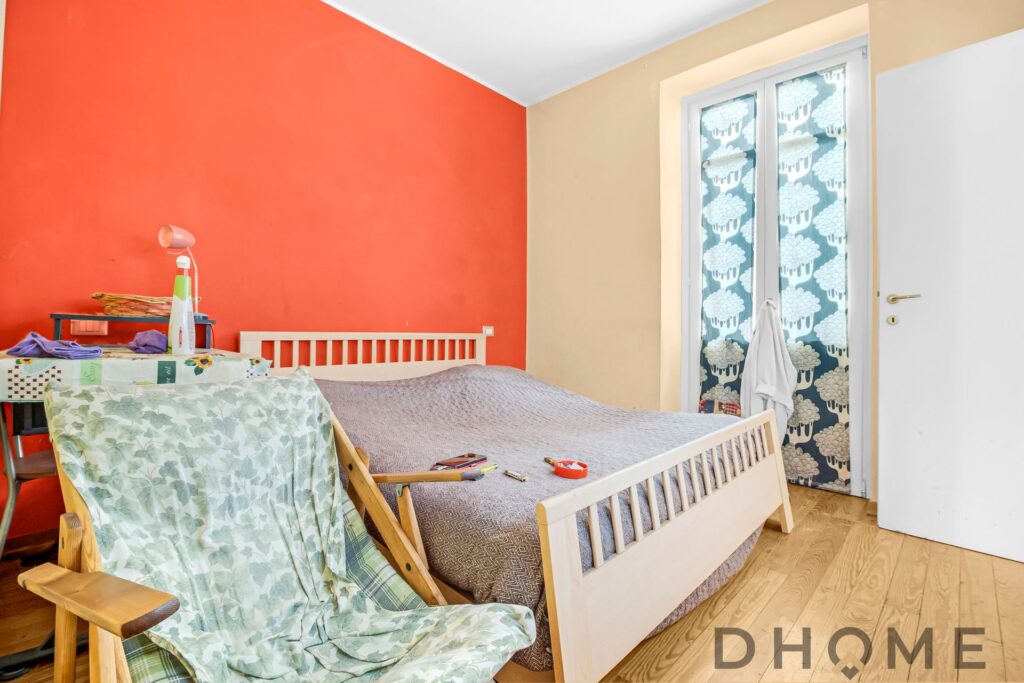 Camera da letto spaziosa e luminosa in bilocale in vendita ad Agliè, con pareti colorate e accessori.