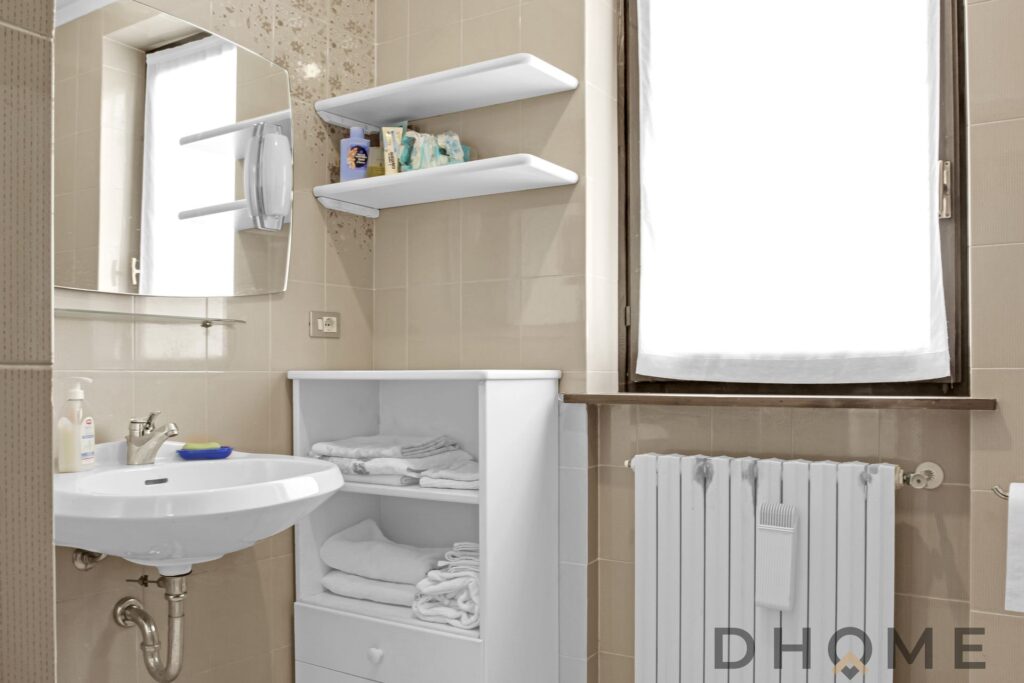 Bagno in quadrilocale indipendente a Primaluna, con lavabo, radiatore e arredi funzionali.