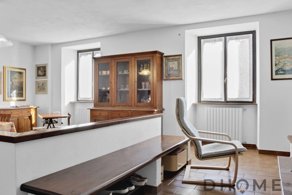 Appartamento quadrilocale in vendita a Primaluna, con arredi classici e ampie finestre che illuminan.