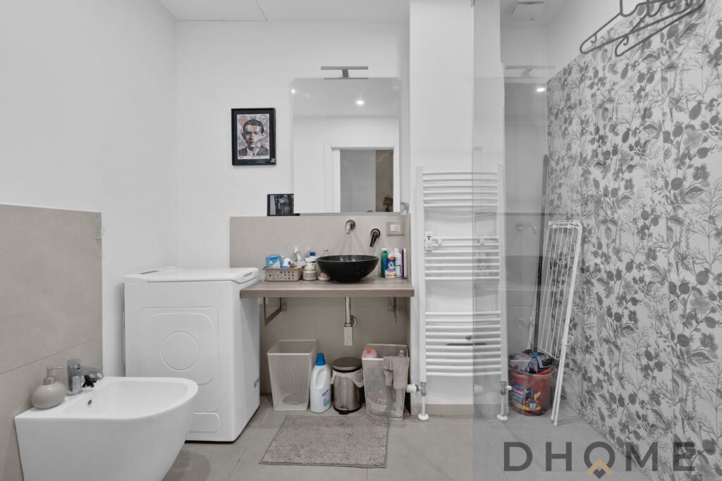 Bagno ristrutturato a Sesto San Giovanni, con lavabo, WC e area lavanderia moderna.