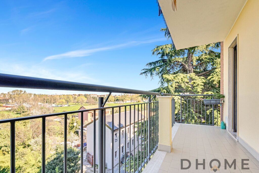 Balcone luminoso con vista panoramica su aree verdi e cielo sereno, ideale per relax e momenti all'a.