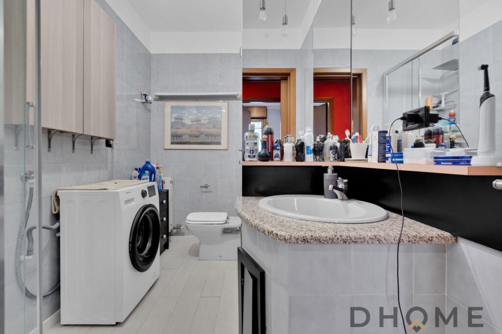 Bagno spazioso con lavatrice e lavabo moderno.